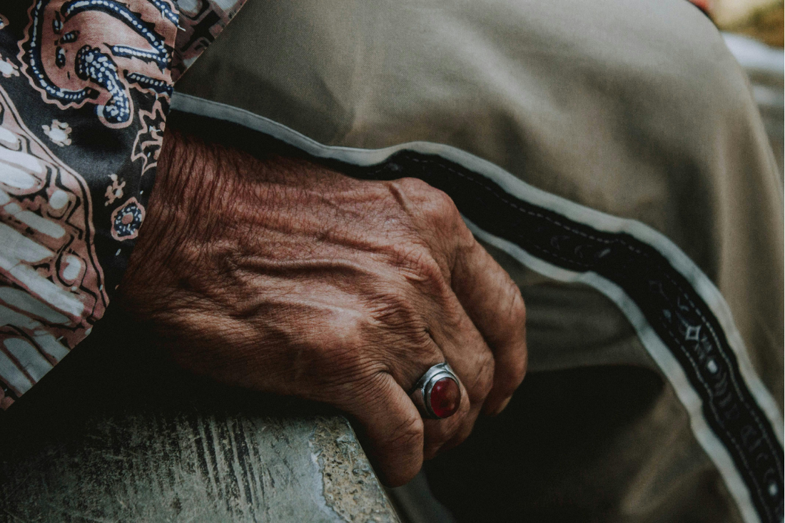 Close-up of an older person’s hand wearing a ring.