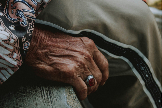 Close-up of an older person’s hand wearing a ring.