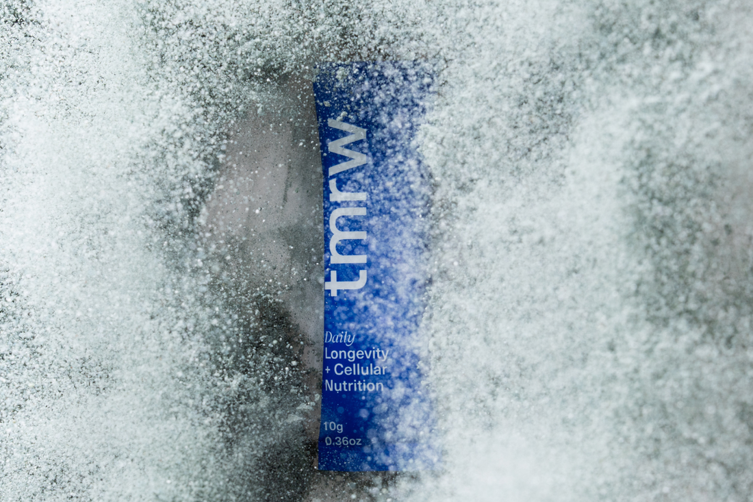 Close-up of a Tmrw longevity supplement sachet partially covered in frost or powder.