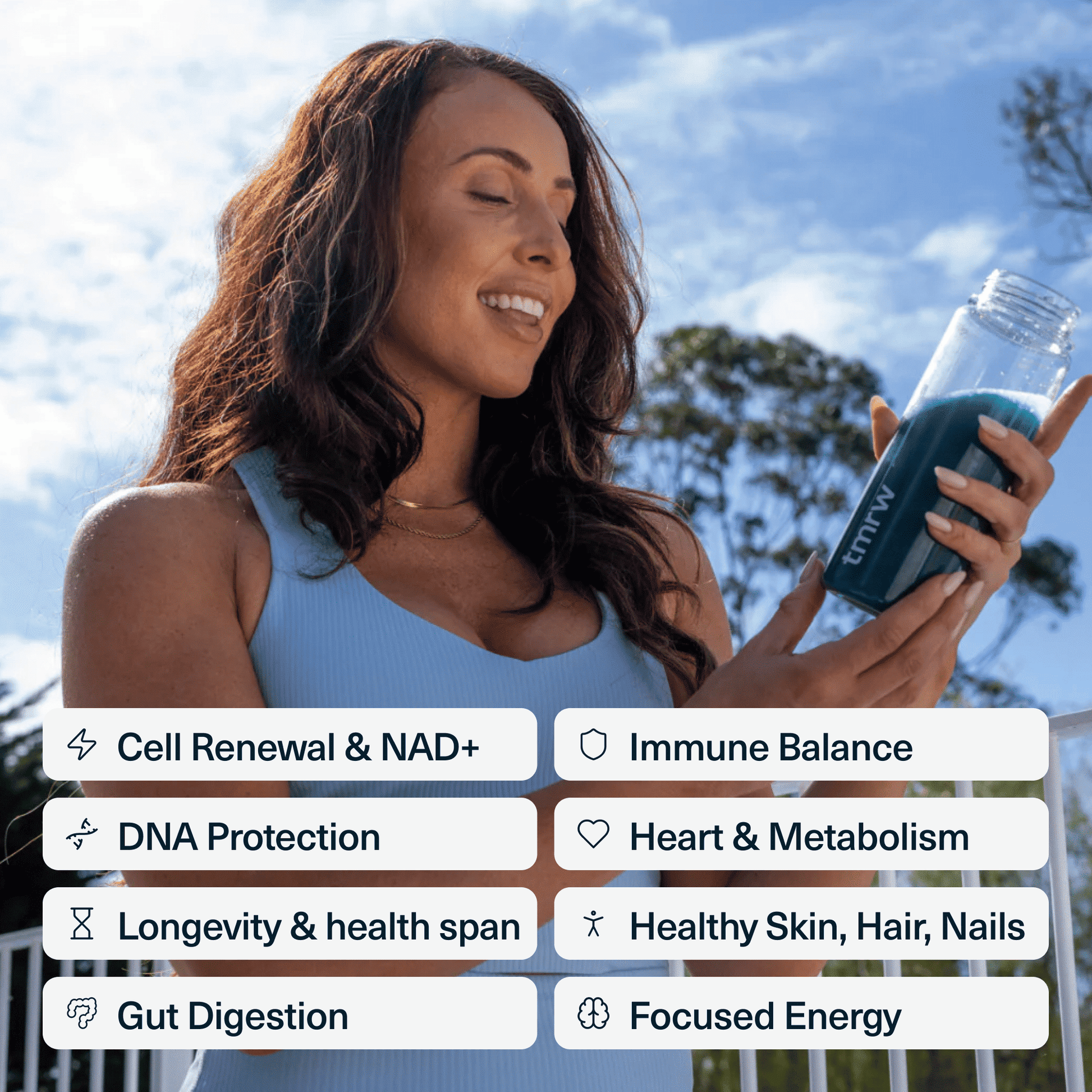 Woman holding Tmrw longevity supplement drink outdoors — daily anti-ageing powder for cellular energy and gut health